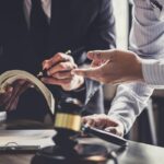 mężczyzna rozmawia z komornikiem sądowym przy stole