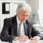 mężczyzna wypisujący dokumenty